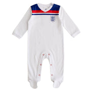 A white England baby sleepsuit with red and blue details, featuring the England national football team's 1982 World Cup kit styling, and a three lions badge.